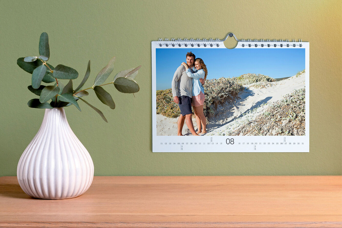 Un couple heureux s'étreint avant une plage. Le calendrier indique le mois d'août.