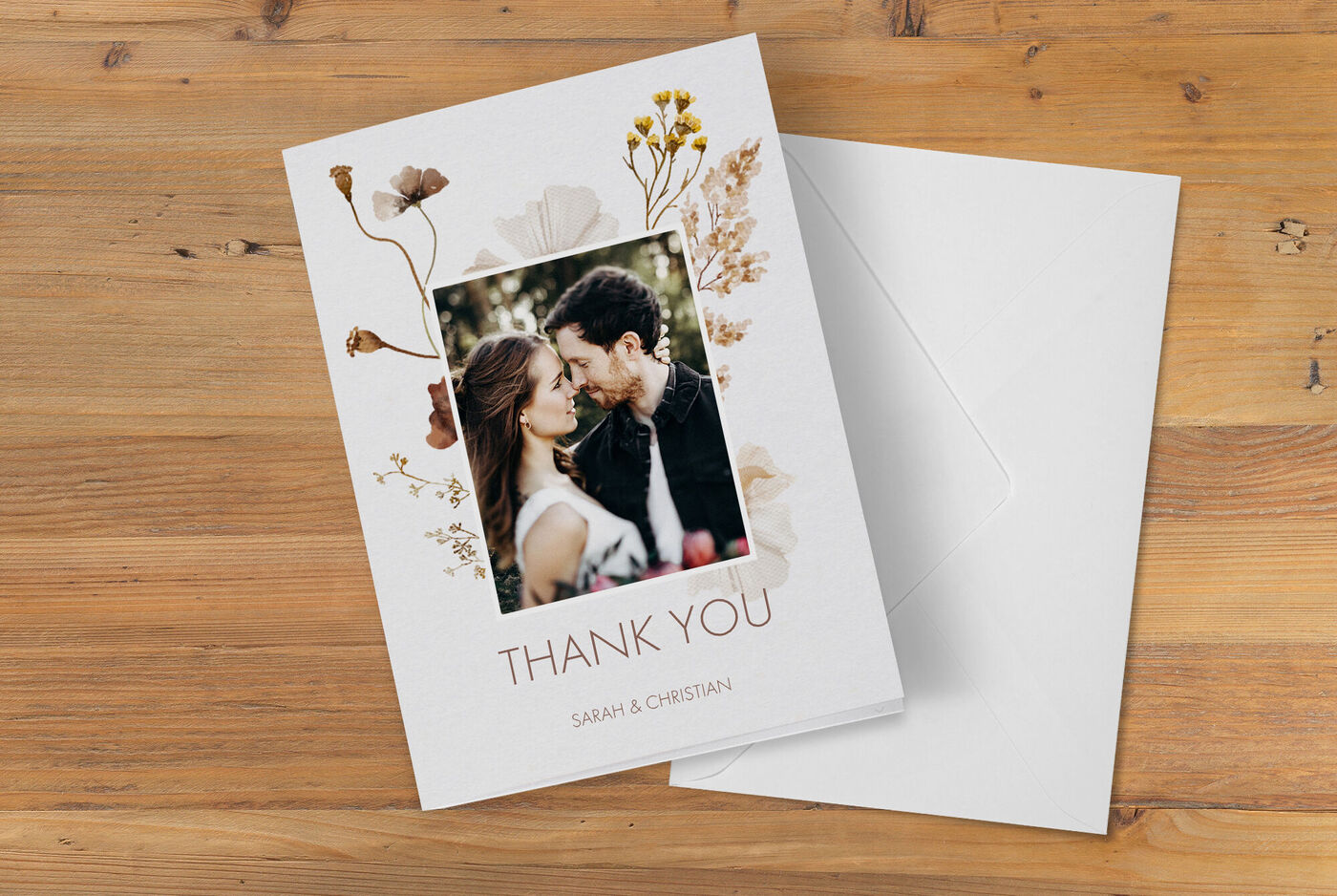 Une carte de remerciement joliment conçue avec des fleurs et une photo d'un couple