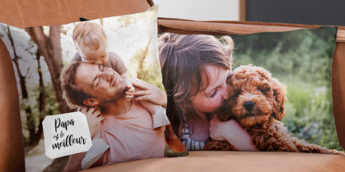 Deux coussins avec des images d'un père avec son enfant et d'un chien sur un canapé.
