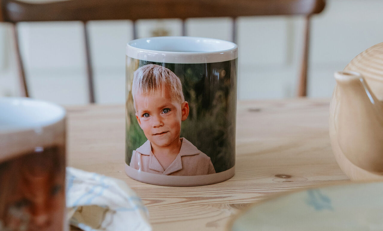 Mug personnalisé portrait, mis en scène sur une table en bois avec ambiance maison