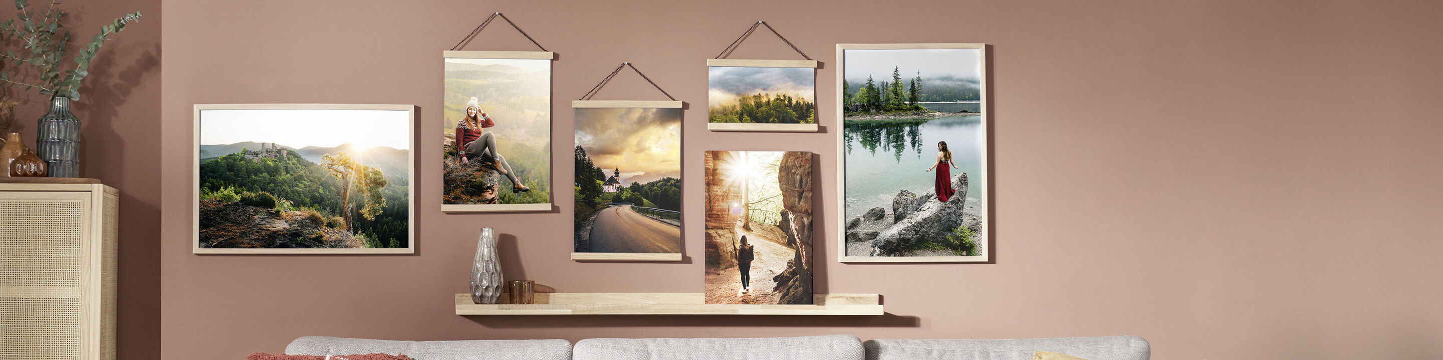 Un mur stylé avec divers tableaux encadrés de paysages naturels et moments de voyage