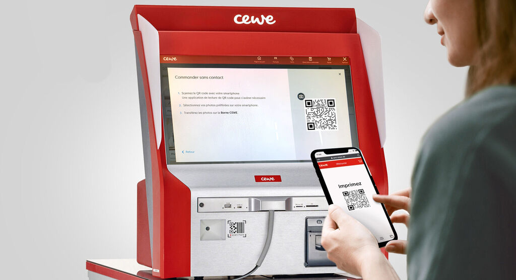 Une personne scanne un code QR à une station CEWE avec son smartphone.