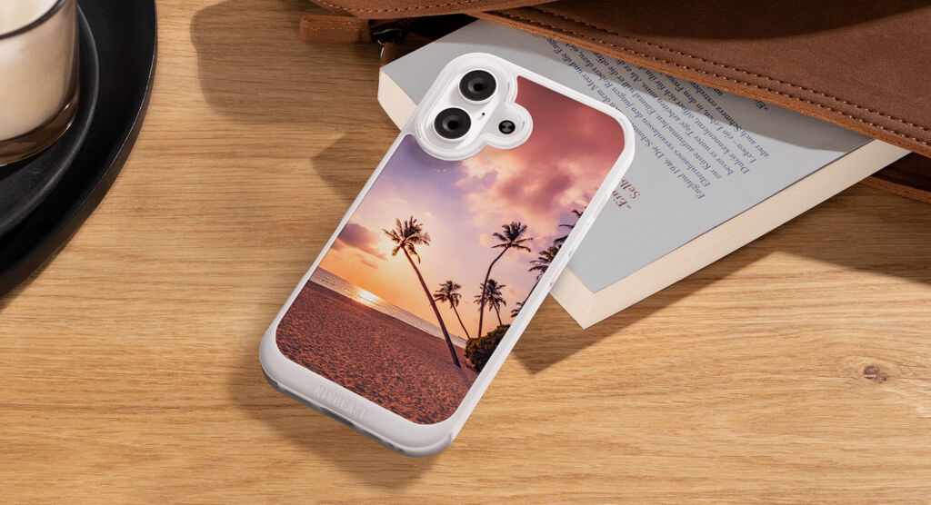 Smartphone posé sur un bureau, protégé par une coque blanche personnalisée avec un coucher de soleil et des palmiers