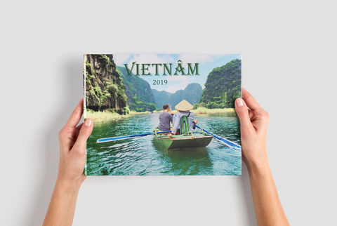 Une personne tient un album photo intitulé "Vietnam 2019" sur un bateau.