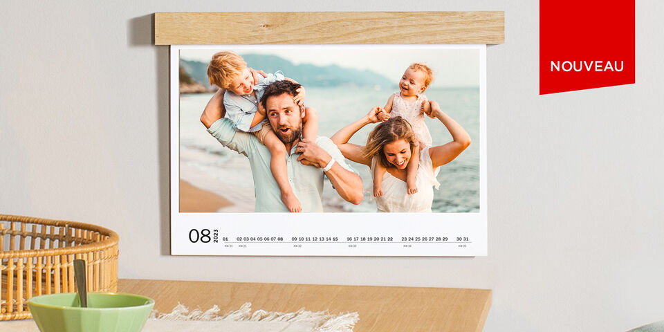 Famille avec enfants à la plage, souriants et heureux, sur un calendrier photo CEWE.