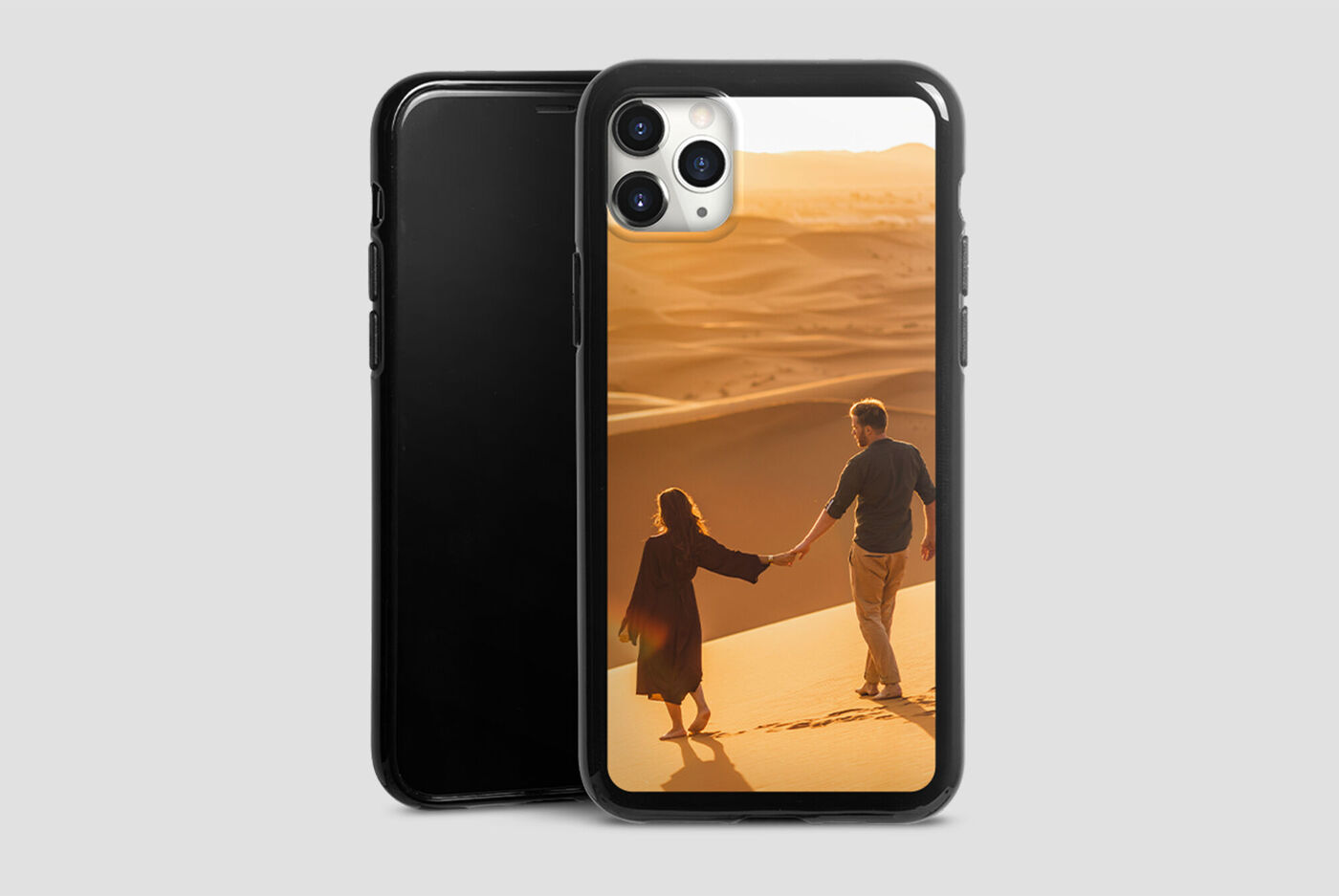 Un couple marchant main dans la main sur une plage de sable au coucher du soleil