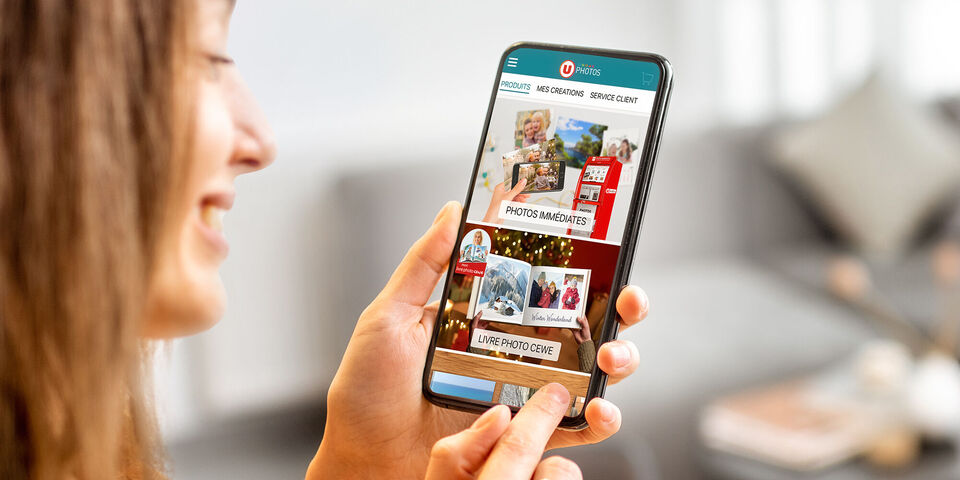 Une personne utilise l'application CEWE sur son smartphone pour créer des photos.