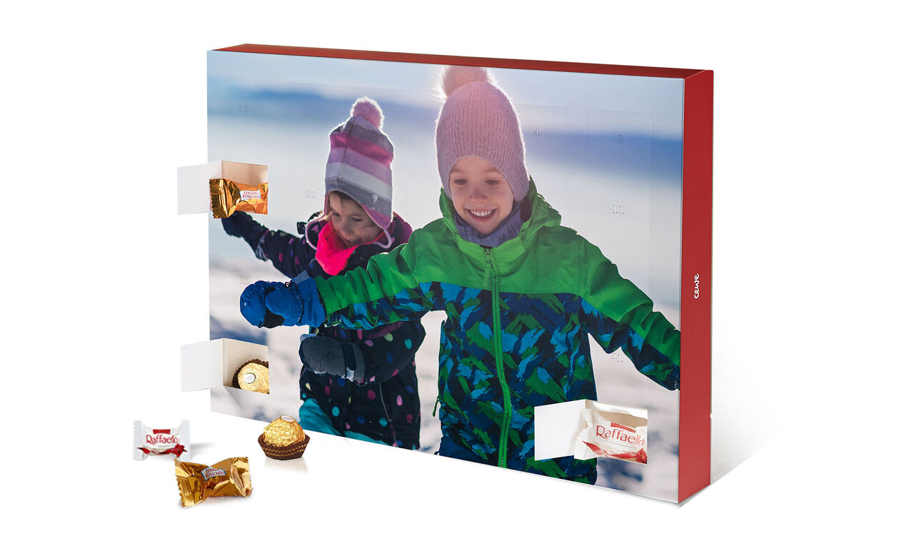 Deux enfants joyeux ouvrant un calendrier de l'Avent dans la neige.