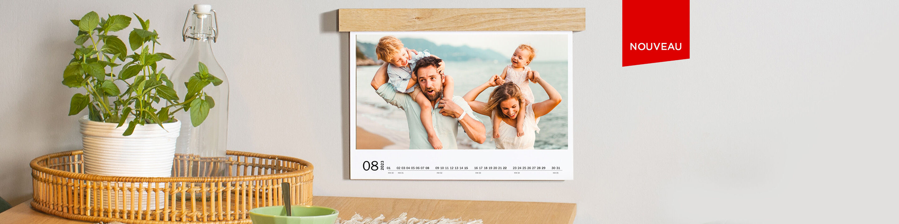 Famille souriante posant devant un calendrier dans un cadre en bois.