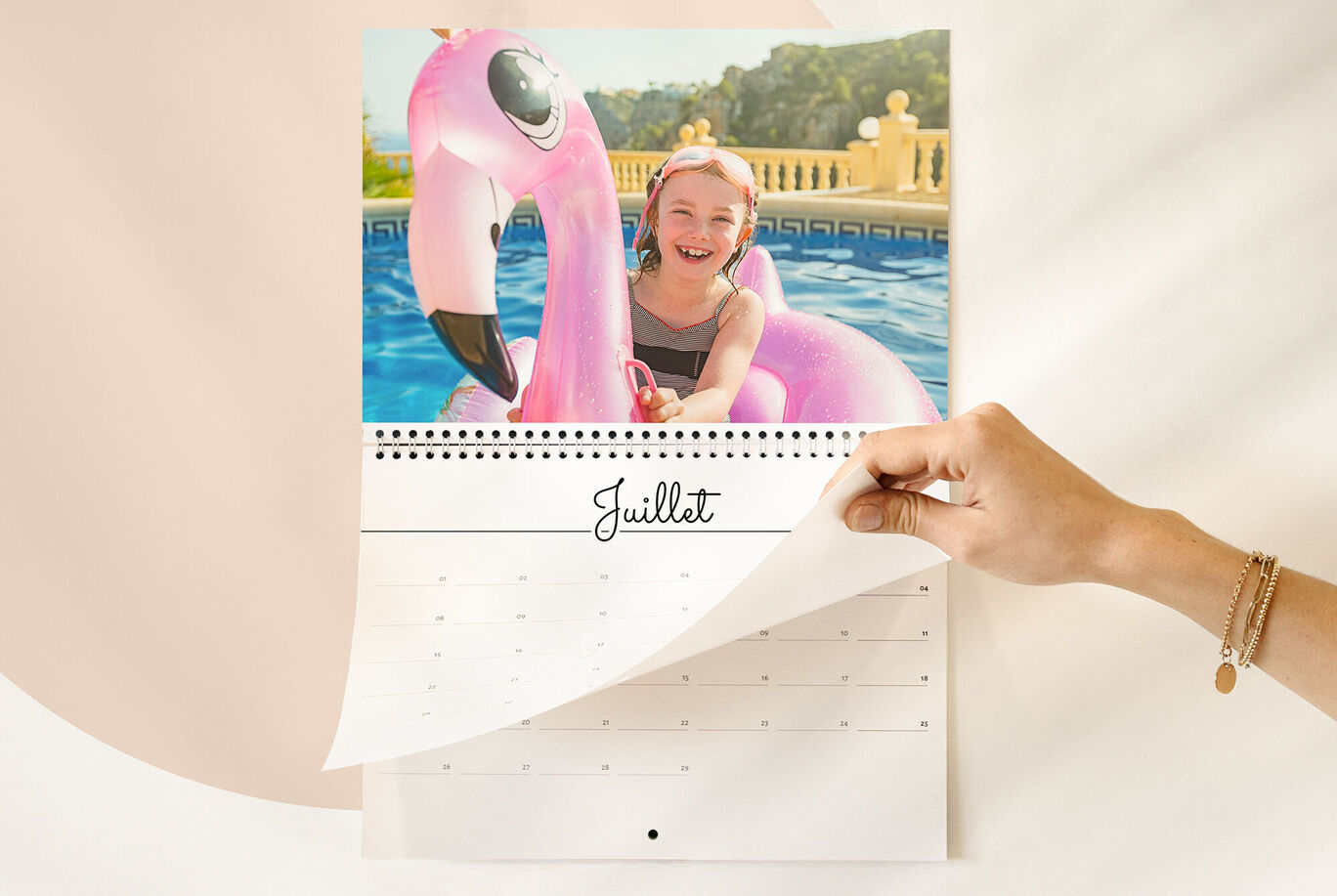 Un enfant avec une bouée en forme de flamingo dans la piscine, feuille de calendrier de juillet