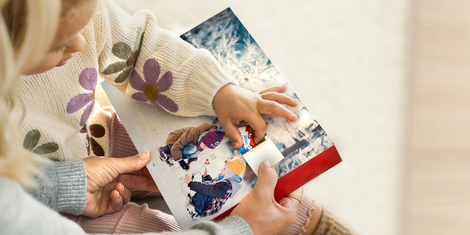 Un enfant ouvre une case d'un calendrier de l'Avent pour découvrir un chocolat