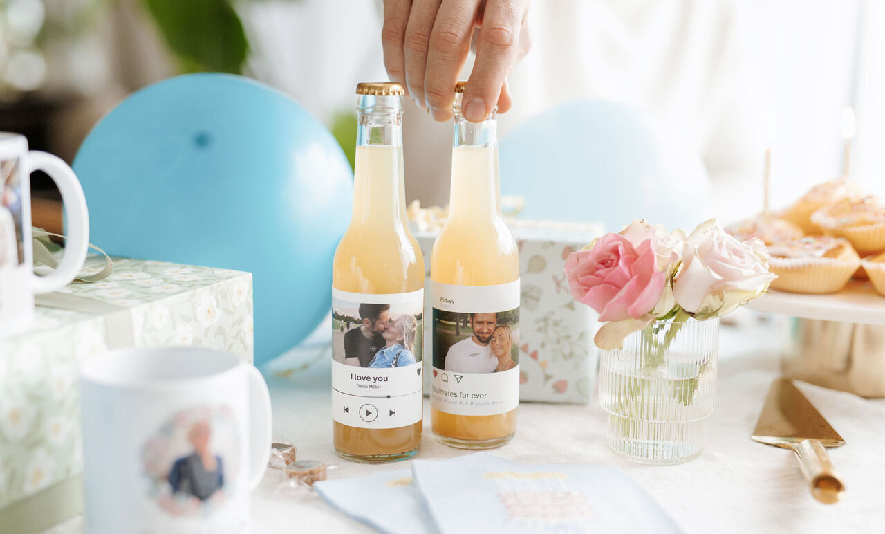 Deux bouteilles personnalisées avec portraits sur une table de fête fleurie